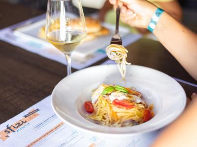 Pasta with cherry tomatoes and basil, served with white wine.