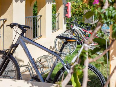 Bicycles parked in an outdoor bike rack on a sunny day.