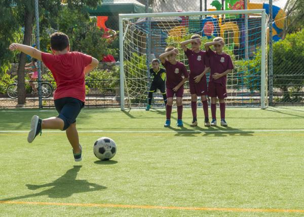 Enfants jouant au football, tir sur coup franc.
