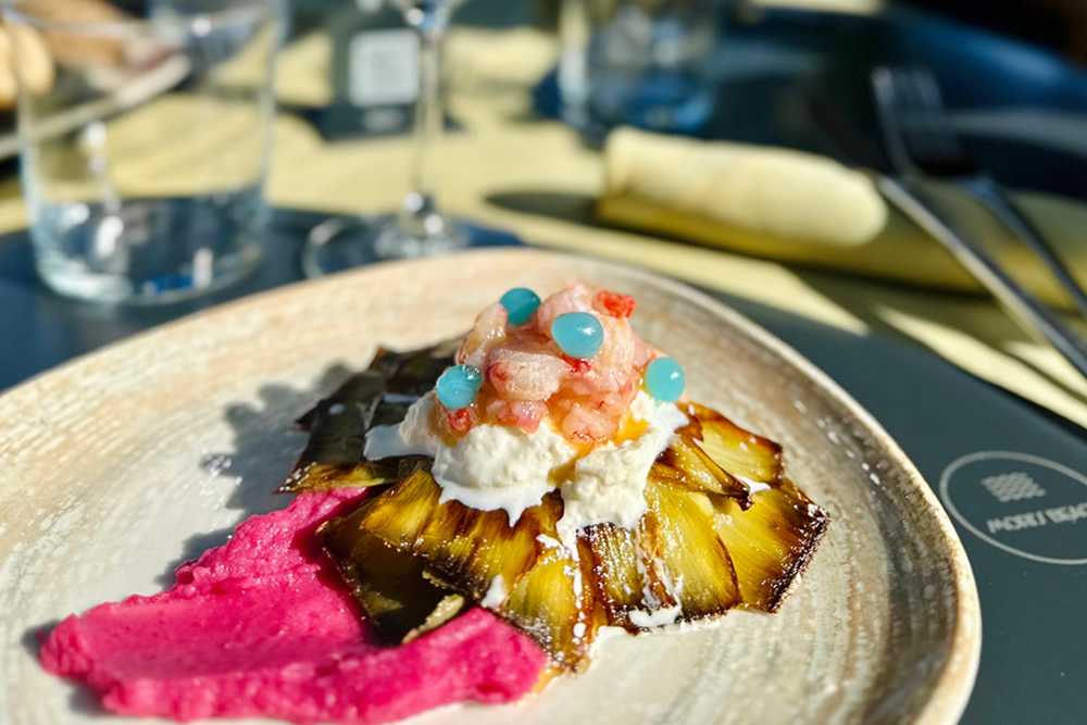 Plat gourmet avec crevettes, ananas caramélisé et crème rose.