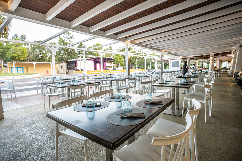 Outdoor restaurant with set tables and stage view.